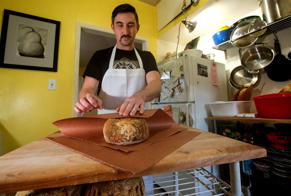 Baker Ian Conover in his home kitchen wrapping freshly made bread for home delivery, a new service in Sonoma. (Photo by Robbi Pengelly/Index-Tribune)