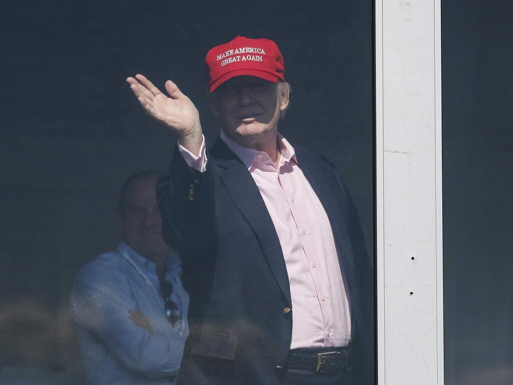 President Donald Trump waves from his presidential viewing stand, Sunday, July 16, 2017, during the U.S. Women's Open Golf tournament at Trump National Golf Club in Bedminster, N.J. (AP Photo/Carolyn Kaster)