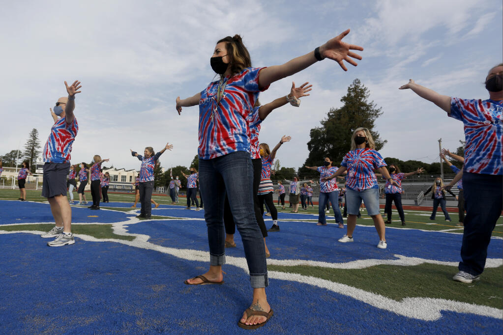Teachers and staff from both Analy and El Molino High Schools perform a dance to the song “We Are Family” by Sister Sledge during a rally on the first day of class at West County High School, on the former Analy High School campus, in Sebastopol, California on Thursday, Aug. 12, 2021. (Beth Schlanker/The Press Democrat)
