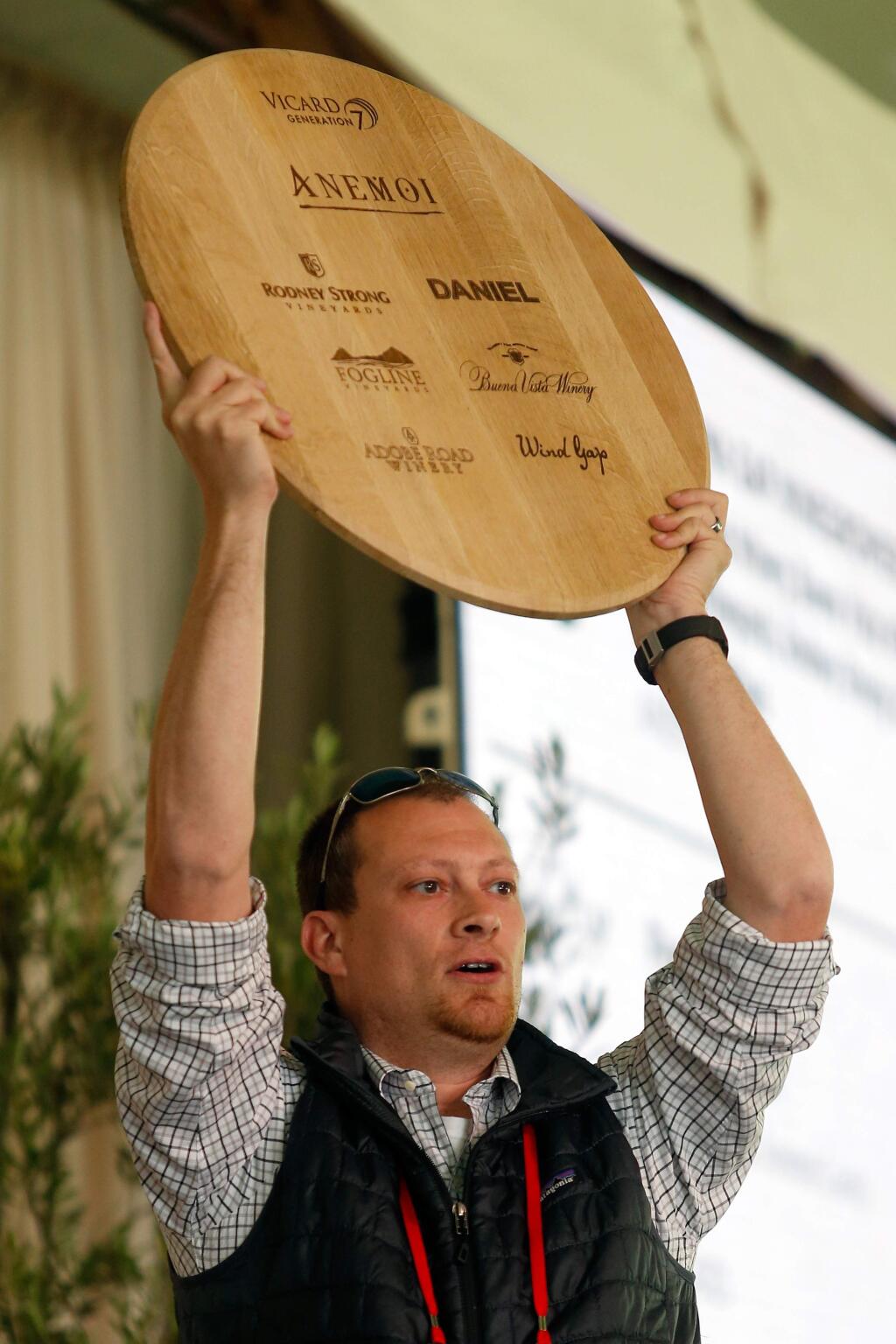 Winemaker Justin Seidenfeld of Rodney Strong Vineyards holds up a sign featuring the wineries of the recently christened Petaluma Gap AVA during bidding at the Sonoma County Barrel Auction at MacMurray Ranch, in Healdsburg, California, on Friday, April 20, 2018. (Alvin Jornada / The Press Democrat)