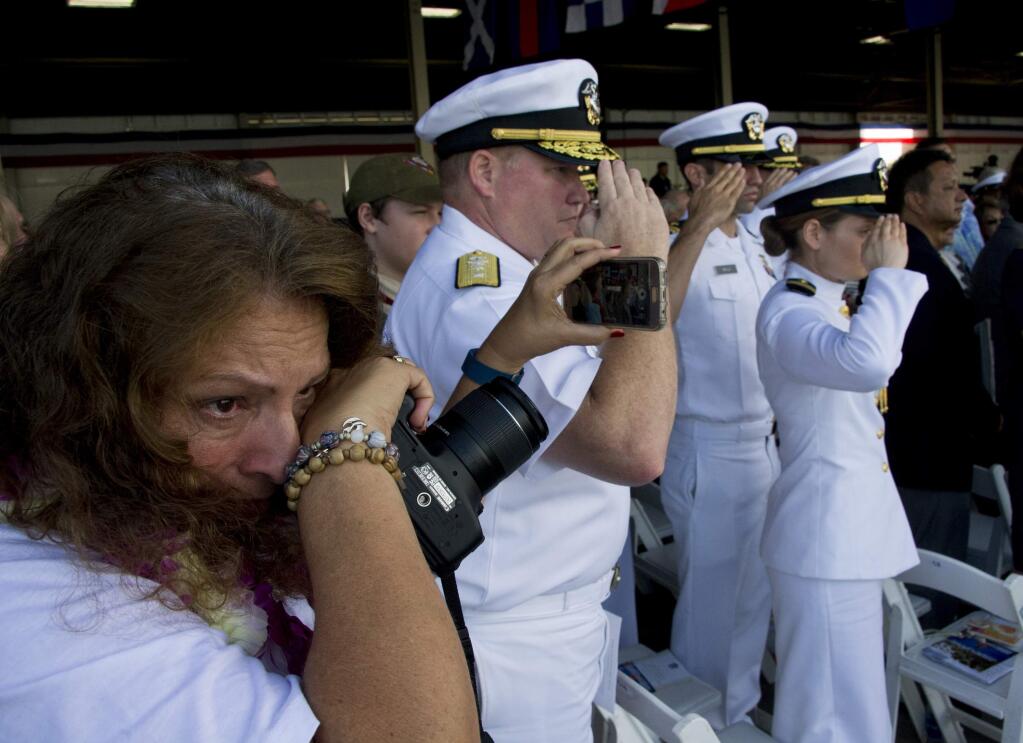 During Rifle Salute, Charlene Miranda-Wood, left, holds back tears as she remembers her father, Vic Miranda, a Pearl Harbor survivor who passed away last year during a commemoration for the 75th anniversary of the Japanese attack on the naval harbor on Wednesday, Dec. 7, 2016 at Kilo Peir in Honolulu. Survivors of the Japanese attack, dignitaries and ordinary citizens attended the ceremony. (Craig T. Kojima/The Star-Advertiser via AP, Pool)