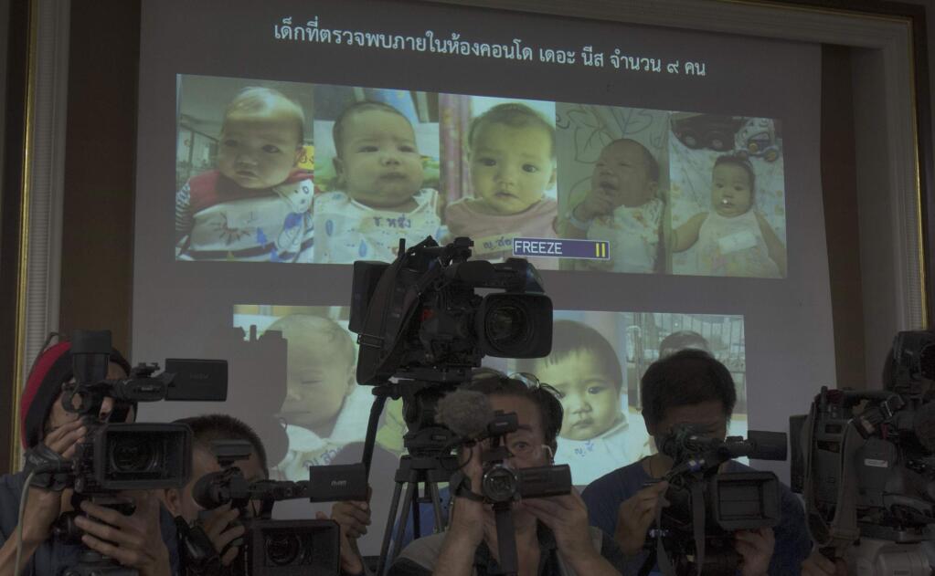 In this Tuesday, Aug. 12, 2014 photo, Thai police display pictures of surrogate babies born to a Japanese man who is at the center of a surrogacy scandal during a press conference at the police headquarters in Chonburi, Thailand. Interpol said Friday it has launched a multinational investigation into what Thailand has dubbed the Baby Factory case: the 24-year-old Japanese businessman who has 16 surrogate babies and an alleged desire to father hundreds more. Police raided a Bangkok condominium earlier this month and found nine babies and nine nannies living in a few unfurnished rooms filled with baby bottles, bouncy chairs, play pens and diapers. They have since identified Mitsutoki Shigeta as the father of those babies - and seven others. (AP Photo/Sakchai Lalit)