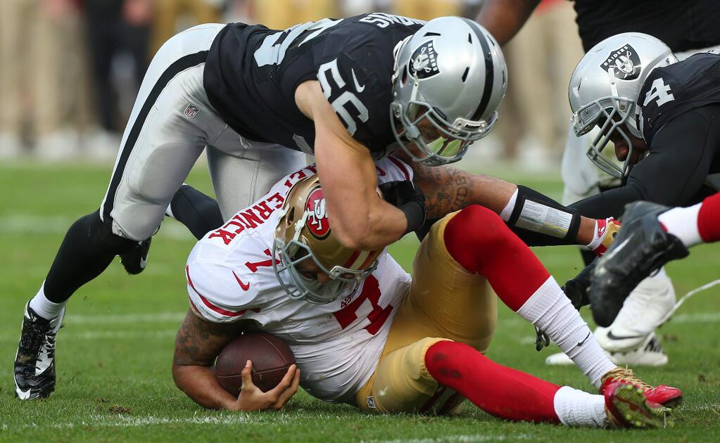 Oakland Raiders linebacker Miles Burris sacks San Francisco 49ers quarterback Colin Kaepernick in the second quarter of a game in Oakland on Sunday, Dec. 7, 2014. The Raiders defeated the 49ers 24-13. (Christopher Chung / The Press Democrat)