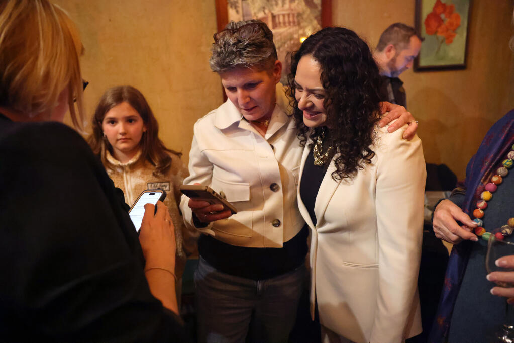 Belia Ramos, right, a candidate for the District 5 Napa County Supervisor, looks at updated election results with friend Tracy Krumpen during party at La Strada Italian restaurant in American Canyon, Tuesday, March 5, 2024. (Beth Schlanker/ The Press Democrat)