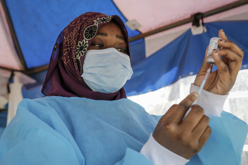 FILE - A nurse prepares to administer an AstraZeneca vaccination against COVID-19, at a district health center giving first, second, and booster doses to eligible people, in the low-income Kibera neighborhood of Nairobi, Kenya, Jan. 20, 2022. In a new analysis released Thursday, April 7, 2022,  the U.N. health agency reviewed 151 studies of COVID-19 in Africa based on blood samples taken from people on the continent between January 2020 and December 2021. WHO said that by last September, about 65% of people tested had some exposure to COVID-19, translating into about 800 million infections. In contrast, by that time, only about 8 million cases had been officially reported to WHO. (AP Photo/Brian Inganga, File)