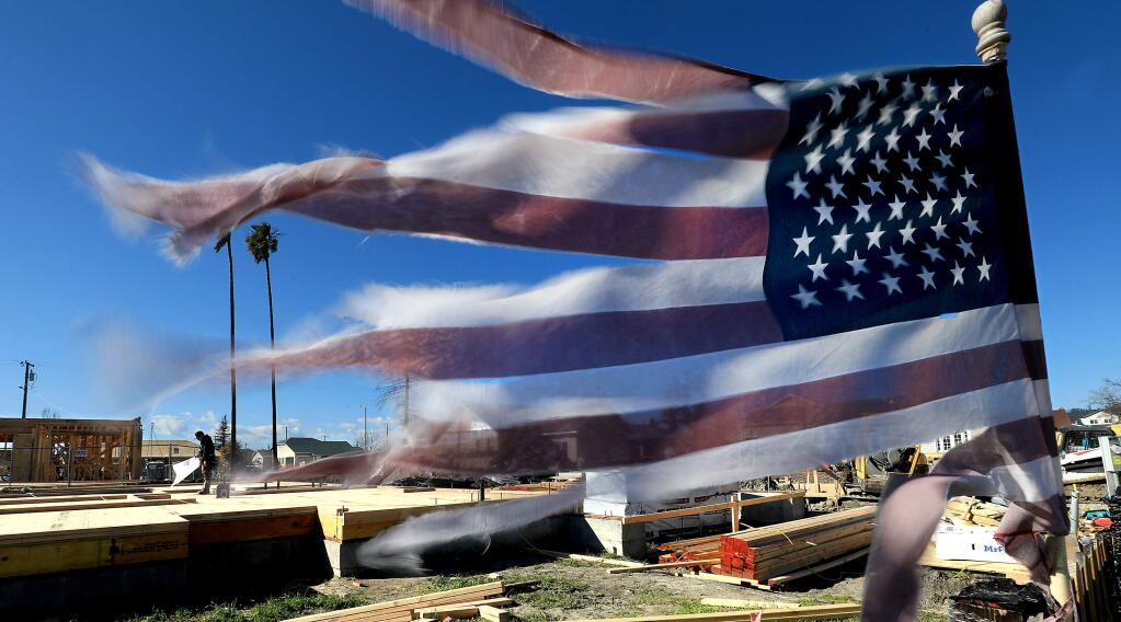 The subfloor of a home on Dogwood Drive is complete as an American Flag, in place since the night of the Tubbs fire, flaps in the breeze, Thursday, Feb. 21, 2019 in Santa Rosa. (Kent Porter / Press Democrat) 2019