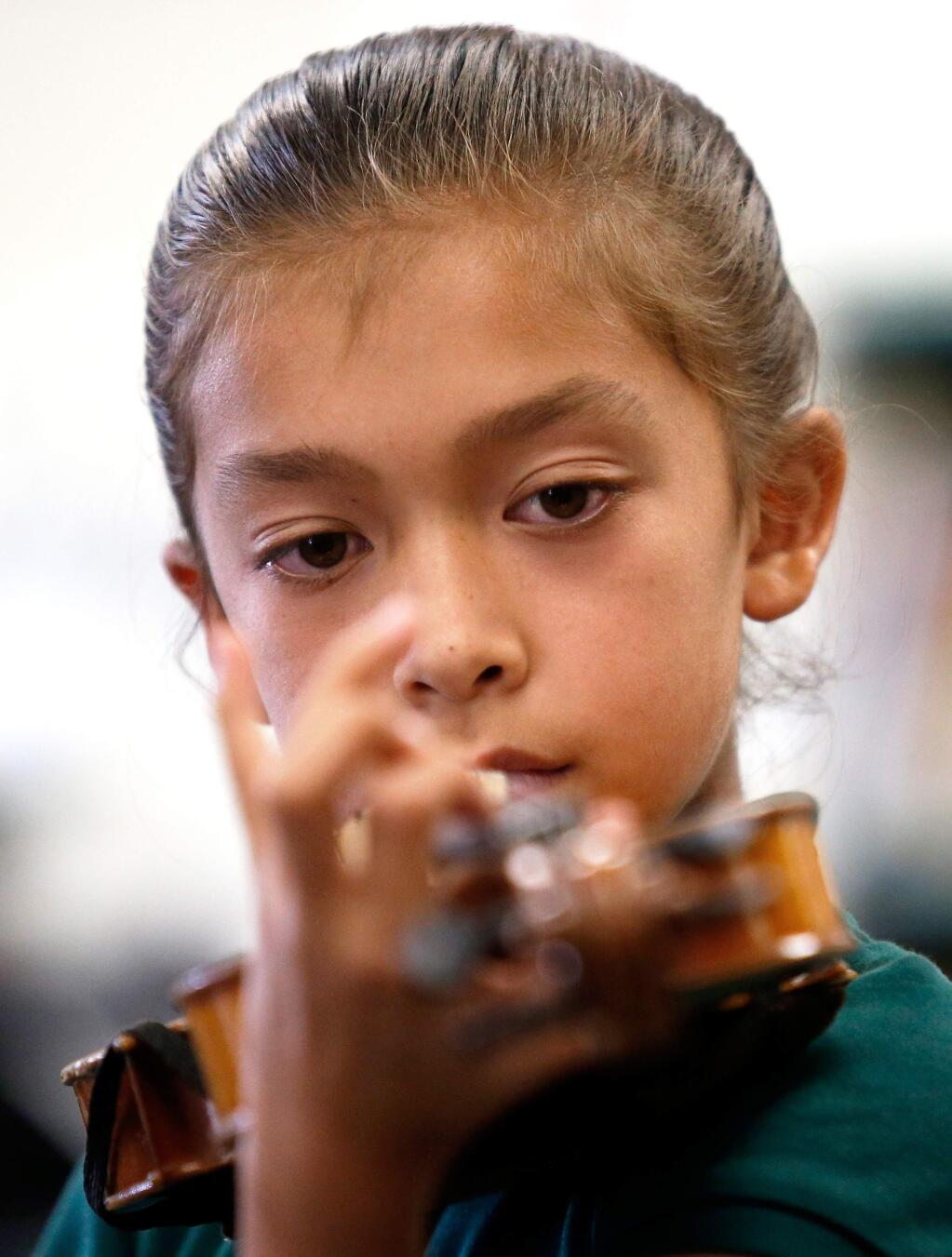 Sixth grader Sofia Santana, 10, plucks a few notes on her violin after she and her classmates received their instruments for the first time during the music blitz program at Luther Burbank Elementary School in Santa Rosa, California, on Thursday, September 13, 2018. (Alvin Jornada / The Press Democrat)
