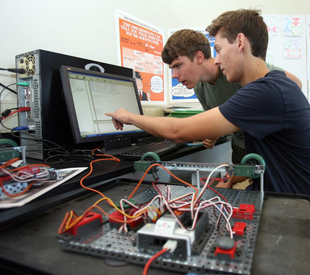 Dan Curren, left, and Thomas De Jong work in robotics C program to program their robot, in the foreground, during their Principles of Engineering class taught by Mrs. Eaton at Petaluma High School on Monday, November 17, 2014. (SCOTT MANCHESTER/ARGUS-COURIER STAFF)