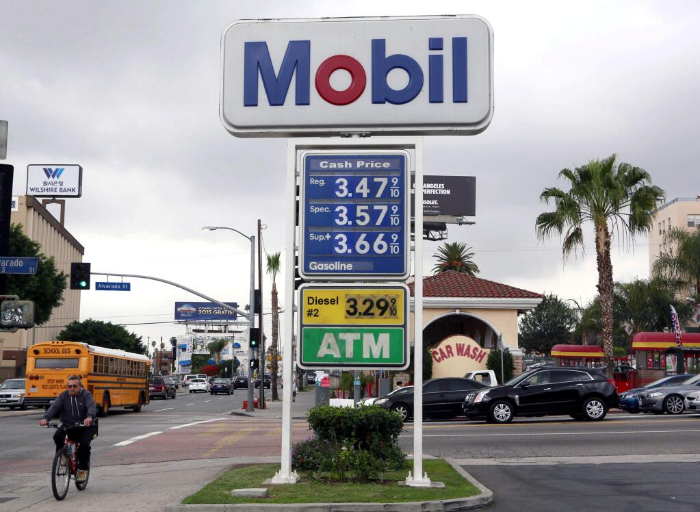 A cyclist rides by a sign at a gas station in Los Angeles posting the latest gas prices on Friday, Feb. 27, 2015. Gas prices in California soared overnight as a result of a combination of supply-and-demand factors worsened by the shutdown of two refineries that produce a combined 16 percent of the states gasoline. (AP Photo/Nick Ut)