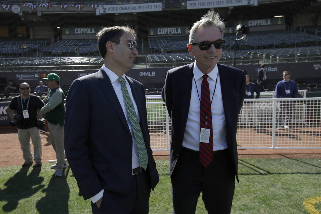 Oakland Athletics President Dave Kaval, left, talks with Executive Vice President of Baseball Operations Billy Beane before the American League wild-card game against the Tampa Bay Rays in Oakland on Wednesday, Oct. 2, 2019. (Jeff Chiu / ASSOCIATED PRESS)