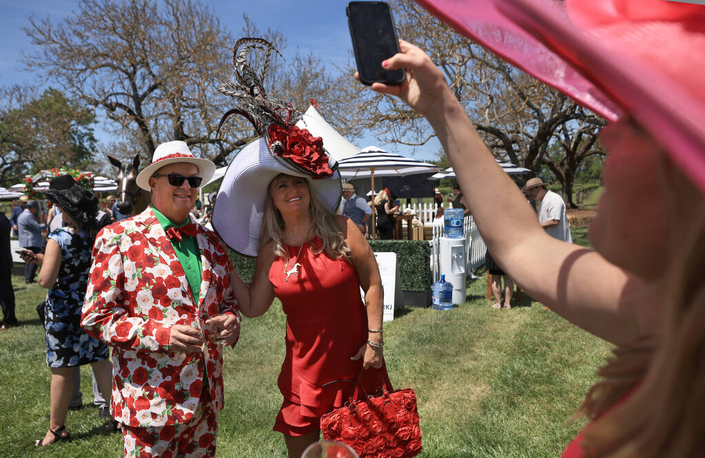 Shaun Takkinen and Randi Miller of Huntington Beach have their picture taken by Maggie Curry of Healdsburg at the Kentucky Derby party at Kendall-Jackson Wine Estate and Gardens in Santa Rosa on Saturday, May 7, 2022. (Kent Porter/The Press Democrat)