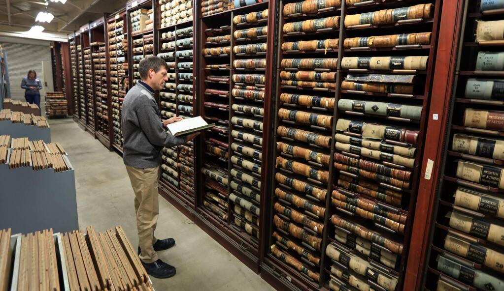 Geoffrey Skinner a cataloging and metadata librarian and Katherine Rinehart, manager of the History and Genealogy of the Sonoma County Library, look over the condition of Sonoma county's historical archive housed on the campus of Los Guilicos past women's detention center, Tuesday Nov. 14, 2017. The October fires came perilously close to the entire campus and archives . (Kent Porter / The Press Democrat