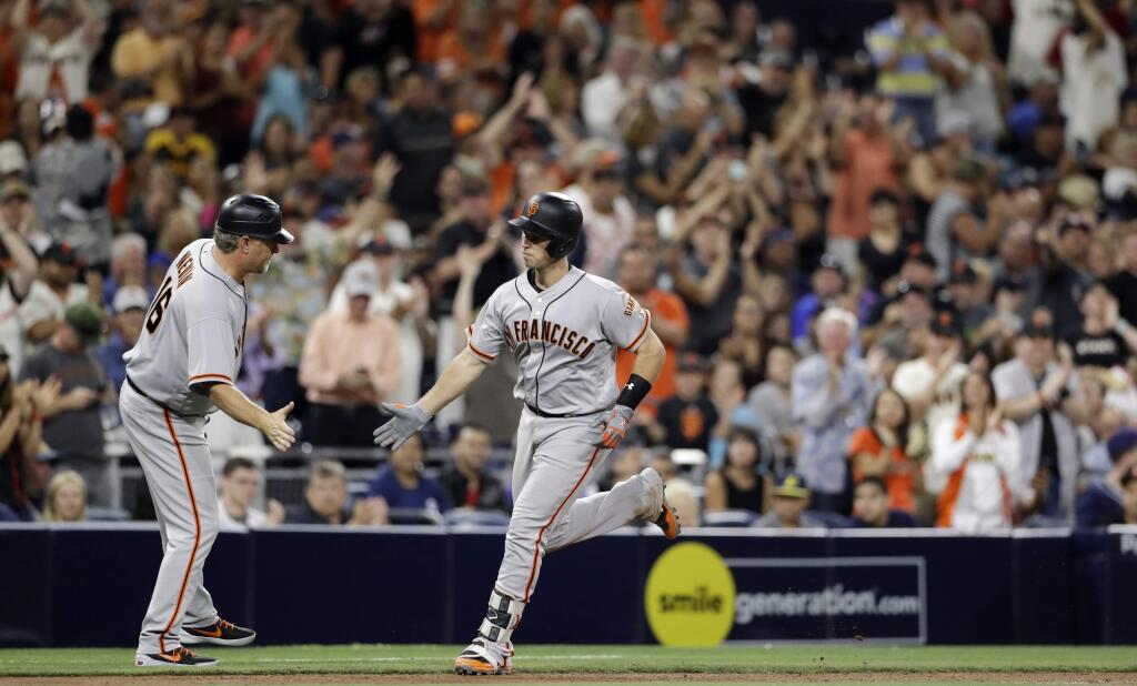 The San Francisco Giants' Buster Posey is greeted by third base coach Phil Nevin after Posey's home run during the seventh inning against the San Diego Padres on Friday, July 14, 2017, in San Diego. (AP Photo/Gregory Bull)