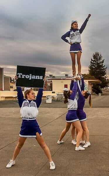 PHS Cheer leader Marlene Cisneros is the flyer, Kykiw McCorkel in foreground rehearse their routine outside before going indoors for the opening of the wrestling match at Petaluma High School in Petaluma on Wednesday, February 11, 2015. (JOHN O'HARA/FOR THE ARGUS-COURIER)