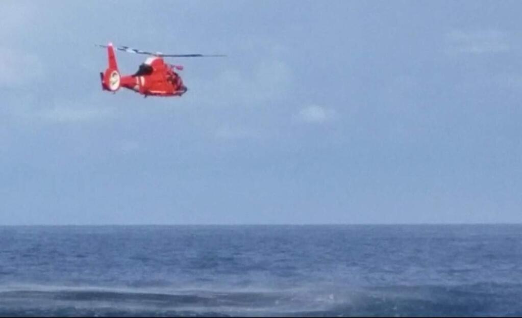 A screengrab from a video that shows a Coast Guard helicopter rescuing a man swept out to sea at Salt Point State Park on Saturday, March 17, 2018. (CALIFORNIA STATE PARKS)