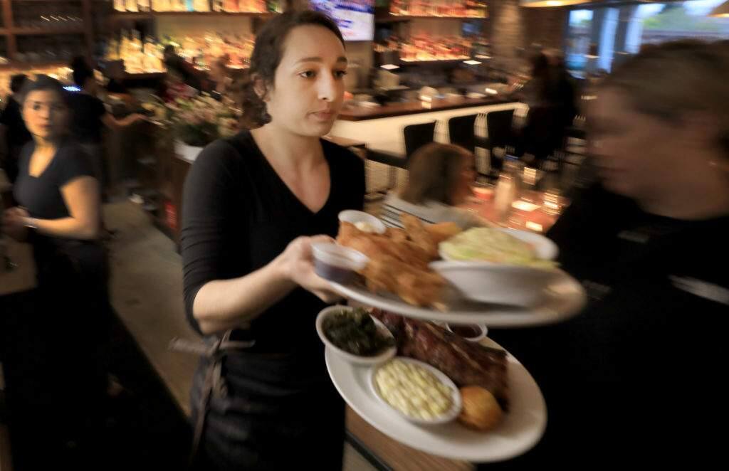 During a soft opening for Sweet T's in Windsor, Monday, March 4, 2019, server Hayley Louzao delivers food to customers. Sweet T's was destroyed during the Tubb's fire as it roared over Fountaingrove and in to Santa Rosa. (Kent Porter / The Press Democrat) 2018