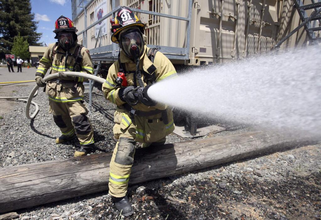 Rancho Adobe Captain Mike Lombardi, left, backs up Engineer Mo Valencia who works the nozle in a hose laying drill at Station 2 in Penngrove on Tuesday July 22, 2014.