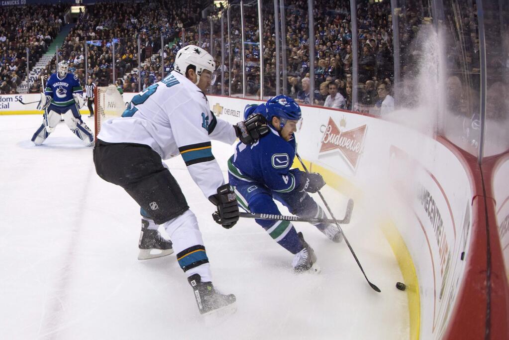 San Jose Sharks' Patrick Marleau, left, checks Vancouver Canucks' Yannick Weber during the first period of a game Tuesday, March 3, 2015, in Vancouver, British Columbia. (AP Photo/The Canadian Press, Darryl Dyck)