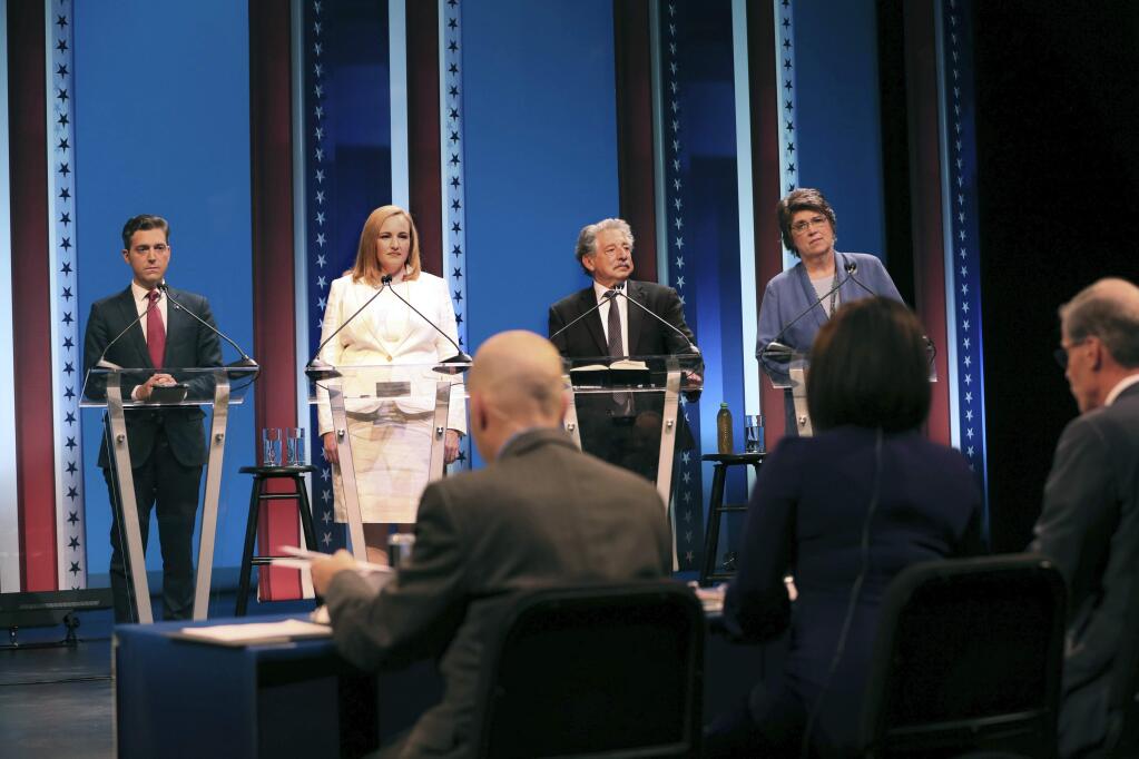 FILE - In this Thursday, July 12, 2018, file photo, four of the eight Democratic candidates for Wisconsin's governor, from left, Josh Made, Kelda Helen Roys, Paul R. Soglin and Kathleen Vinehout stand on stage prior to a debate at the UWM MainStage Theatre in Milwaukee. Wisconsin's primary election will decide which Democrat challenges Republican Gov. Scott Walker this fall and whom Republicans back in a big-money race for U.S. Senate. (Michael Sears/Milwaukee Journal-Sentinel via AP, File)