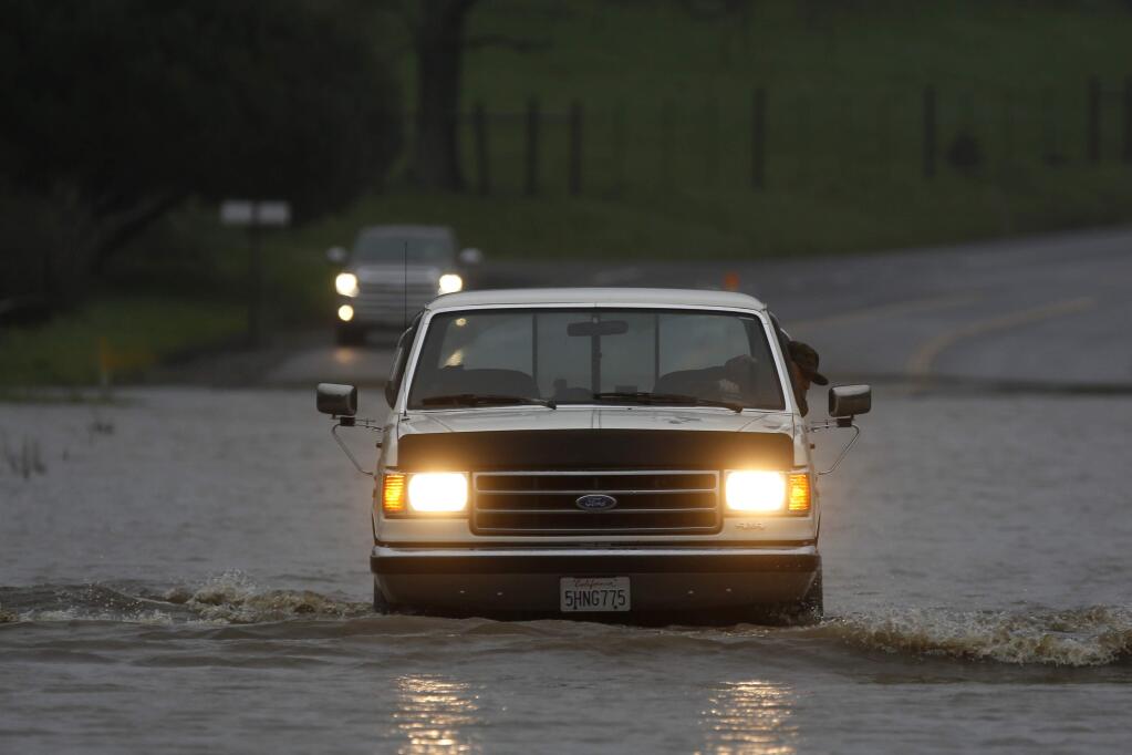 A motorist drives through flood water on Valley Ford near Bloomfield Rd in Bloomfield, on Tuesday, February 7, 2017. (BETH SCHLANKER/ The Press Democrat)
