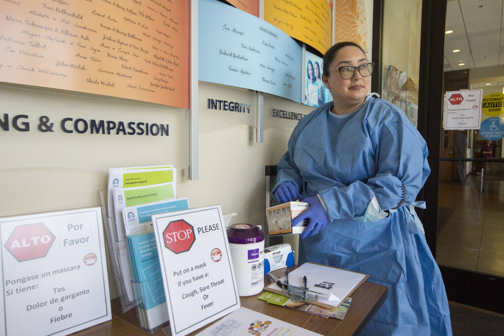 Medical assistant Grincelda Saldivar waits for patients at the entrance to the Sonoma Valley Community Health Center on Highway 12 in Boyes Hot Springs on Monday, Mar. 16. (Photo by Robbi Pengelly/Index-Tribune)