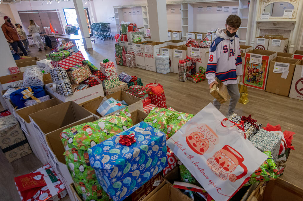 SRJC student Brady Curotto Volunteers with Secret Santa to sort and process donated holiday gifts at their distribution center in Montgomery Village in Santa Rosa, Wednesday, Dec. 21, 2022. (Chad Surmick/The Press Democrat)