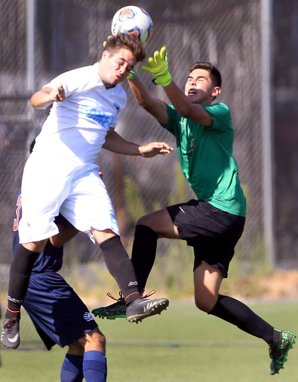 Santa Rosa Junior College goalkeeper Cristian Hernandez makes a save on goal over the header of Contra Costa's Eduardo Torres, during the Bear Cubs' home opening rout of the Comets. (Kent Porter / The Press Democrat)