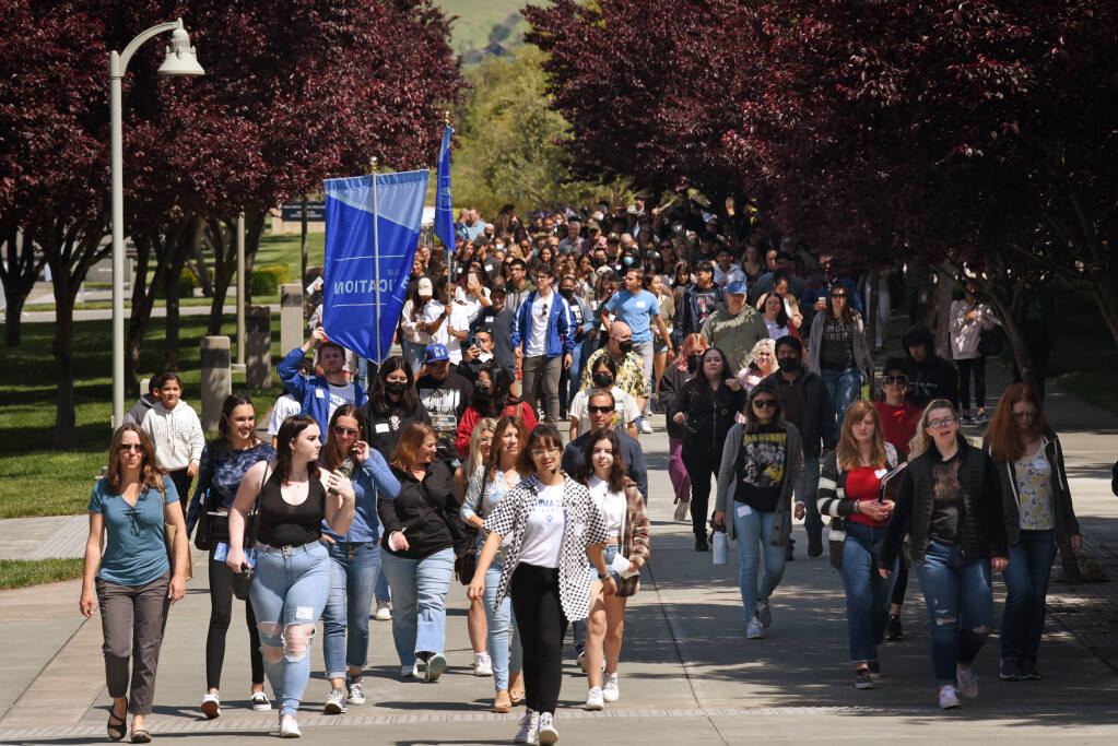 Bee Ucio, 21, in checkered coat, leads a large crowd of incoming students and their family members during Seawolf Decision Day, an opportunity to explore the academic programs and campus life at Sonoma State University in Rohnert Park, Calif., on Saturday, April 23, 2022. (Erik Castro/for The Press Democrat)