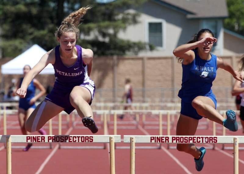 DARRYL BUSH/FOR THE PRESS DEMOCRATPetaluma High's Sydney Dennis, left, hads to victory in the girls 300-meter hurdles, one of three events she won in leading Petaluma to the team title in the Sonoma County League championship meet.