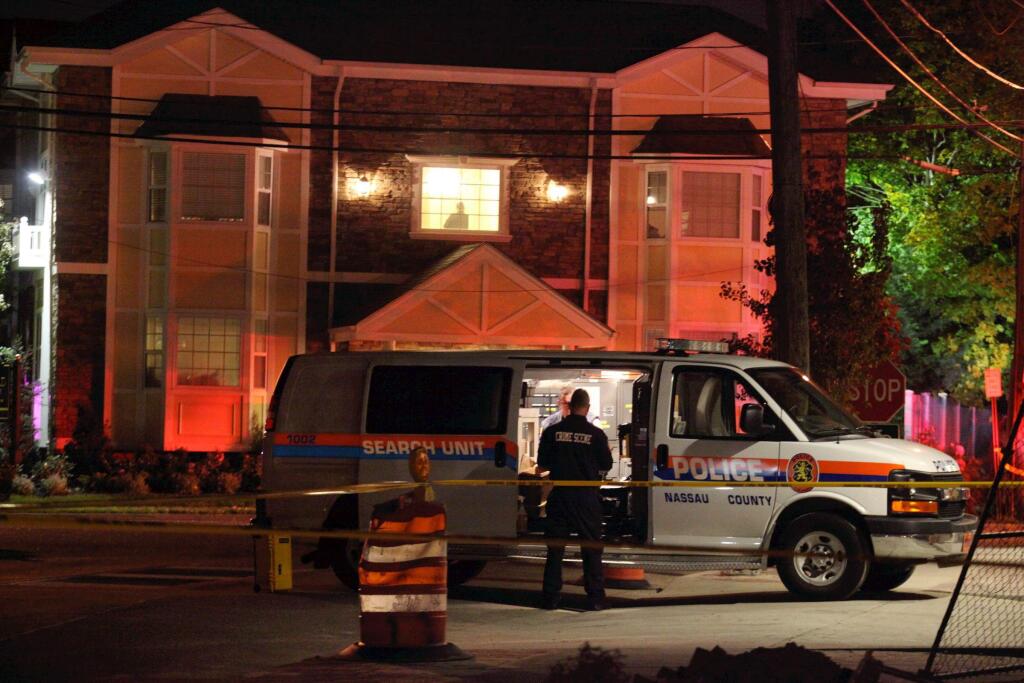 Nassau County police investigate a homicide in Farmingdale, N.Y., Tuesday, Oct. 28, 2014. Police are investigating the link between a woman killed at the Farmingdale apartment building and a man struck by a LIRR train at the nearby train station. (AP Photo/Newsday, Howard Schnapp) NYC LOCALS OUT