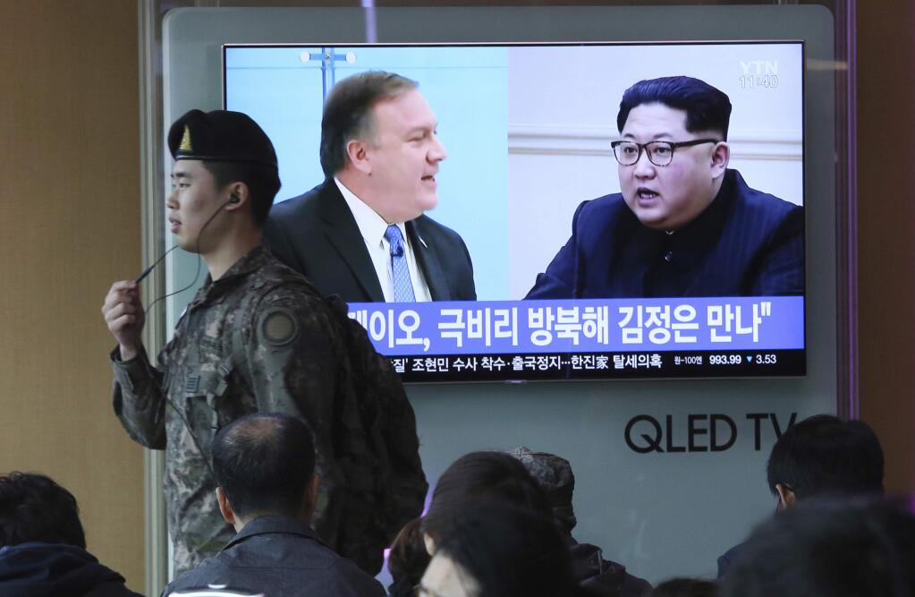 A South Korean army soldier passes by a TV screen showing file footage of CIA Director Mike Pompeo, left, and North Korean leader Kim Jong Un during a news program at the Seoul Railway Station in Seoul, South Korea, Wednesday, April 18, 2018. Pompeo recently traveled to North Korea to meet with leader Kim Jong Un, a highly unusual, secret visit undertaken as the enemy nations prepare for a meeting between President Donald Trump and North Korean leader Kim Jong Un. The signs read: ' Mike Pompeo meets with Kim Jong Un.' (AP Photo/Ahn Young-joon)