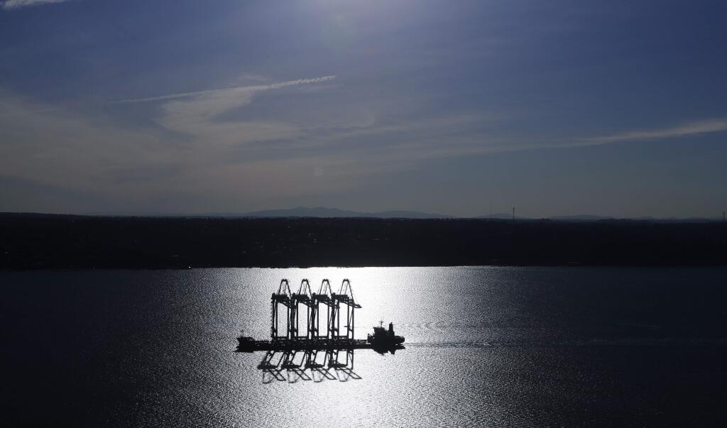 FILE - In this March 5, 2019, file photo the Zhen Hua 31 heavy-lift ship carrying four super-post-Panamax container cranes is silhouetted by the sun as it sails into Commencement Bay in Tacoma, Wash. Most economists were already worried that the odds of a recession are rising, and most of the worries stem from the U.S.-China trade war. (AP Photo/Ted S. Warren, File)