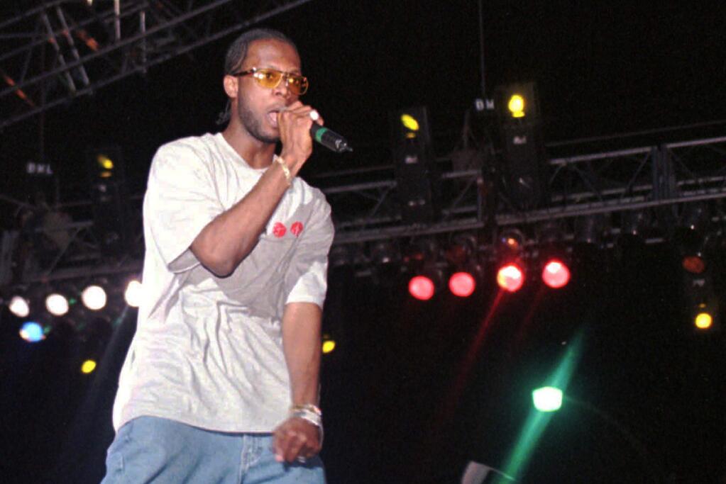 FILE - In this April 12, 1997, file photo, Prakazrel 'Pras' Michel, part of the group the Fugees, sings on stage during a concert in Port-au-Prince, Haiti. A lawyer for one of the founding members of the 1990s hip hop group the Fugees says his client is facing charges related to 2012 campaign contributions. Defense lawyer Barry Pollack said Friday, May 10, 2019, that Michel is innocent and looks forward to having the case heard by a jury.(AP Photo/Daniel Morel, File)