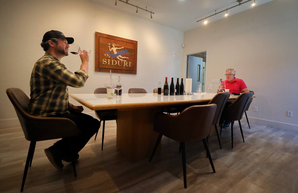 Winemakers Matt Revelette, left, and Adam Lee work on blending wines while maintaining the proper social distance at Siduri Wines, in Santa Rosa on Thursday, June 18, 2020. (Christopher Chung/ The Press Democrat)