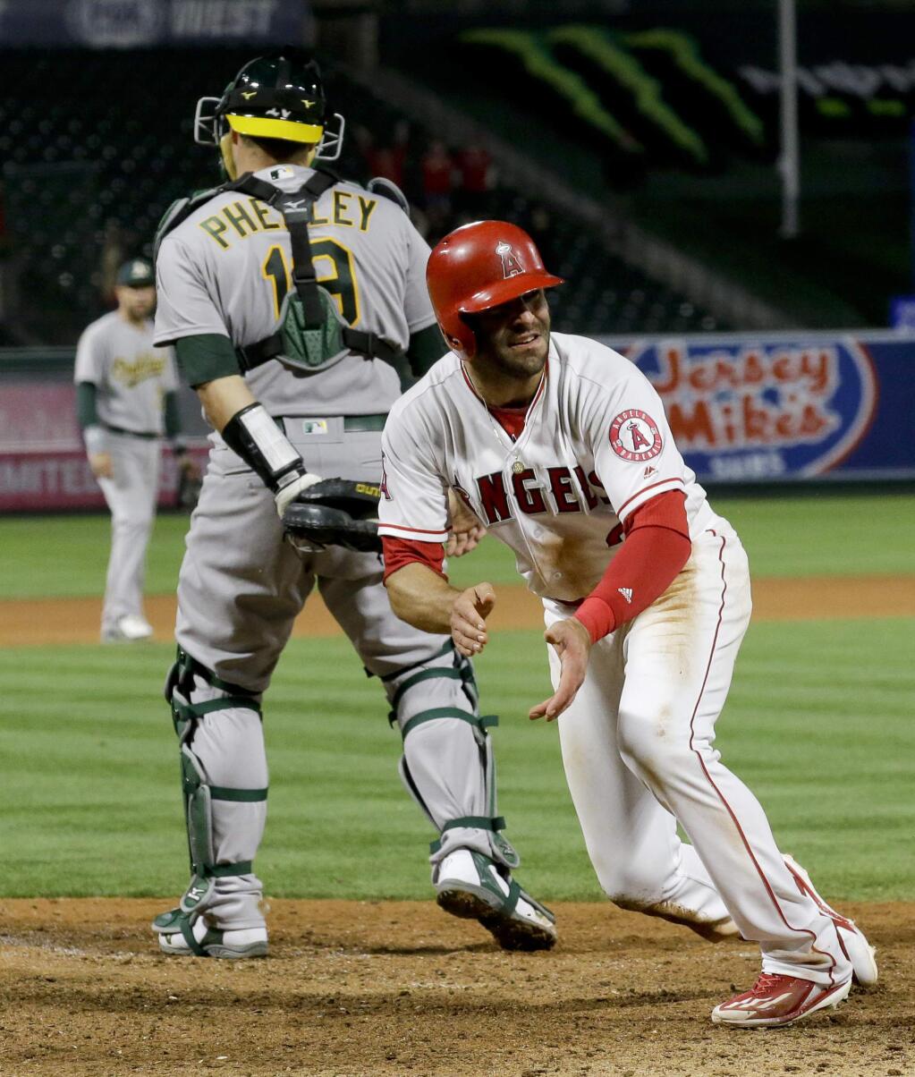 Los Angeles Angels' Danny Espinosa celebrates after scoring the game-winning run on Kole Calhoun's single against the Oakland Athletics during the 11th inning of a baseball game in Anaheim, Calif., Tuesday, April 25, 2017. The Angels won 2-1. (AP Photo/Chris Carlson)