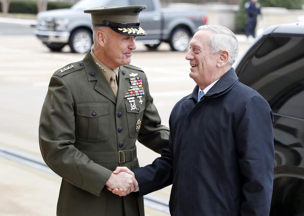 FILE - In this Jan. 21, 2107 file photo, Joint Chiefs Chairman Gen. Joseph Dunford greets Defense Secretary Jimn Mattis at the Pentagon. A new military strategy to meet President Donald Trump's demand “to obliterate” the Islamic State group is likely to deepen U.S. military involvement in Syria, possibly with more ground troops, even as the current U.S. approach in Iraq appears to be working and will require fewer changes. Dunford said Feb. 23 that the strategy will take aim not just at the Islamic State but at al-Qaida and other extremist organizations in the Middle East and beyond whose goal is to attack the United States. He emphasized that it would not rest mainly on military might. (AP Photo/Alex Brandon, File)