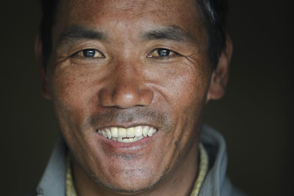 In this March 26, 2018 file photo, Nepalese veteran Sherpa guide, Kami Rita, 48, poses for a photograph at his rented apartment in Kathmandu, Nepal. Rita, scaled Mount Everest on Wednesday morning May 16 for the 22nd time, setting the record for most climbs of the world's highest mountain, officials said. (AP Photo/Niranjan Shrestha, File)
