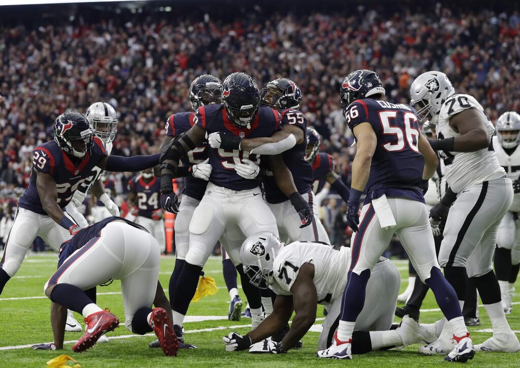Houston Texans defensive end Jadeveon Clowney (90) is congratulated after making an interception against the Oakland Raiders during the first half Saturday, Jan. 7, 2017, in Houston. (AP Photo/Eric Gay)