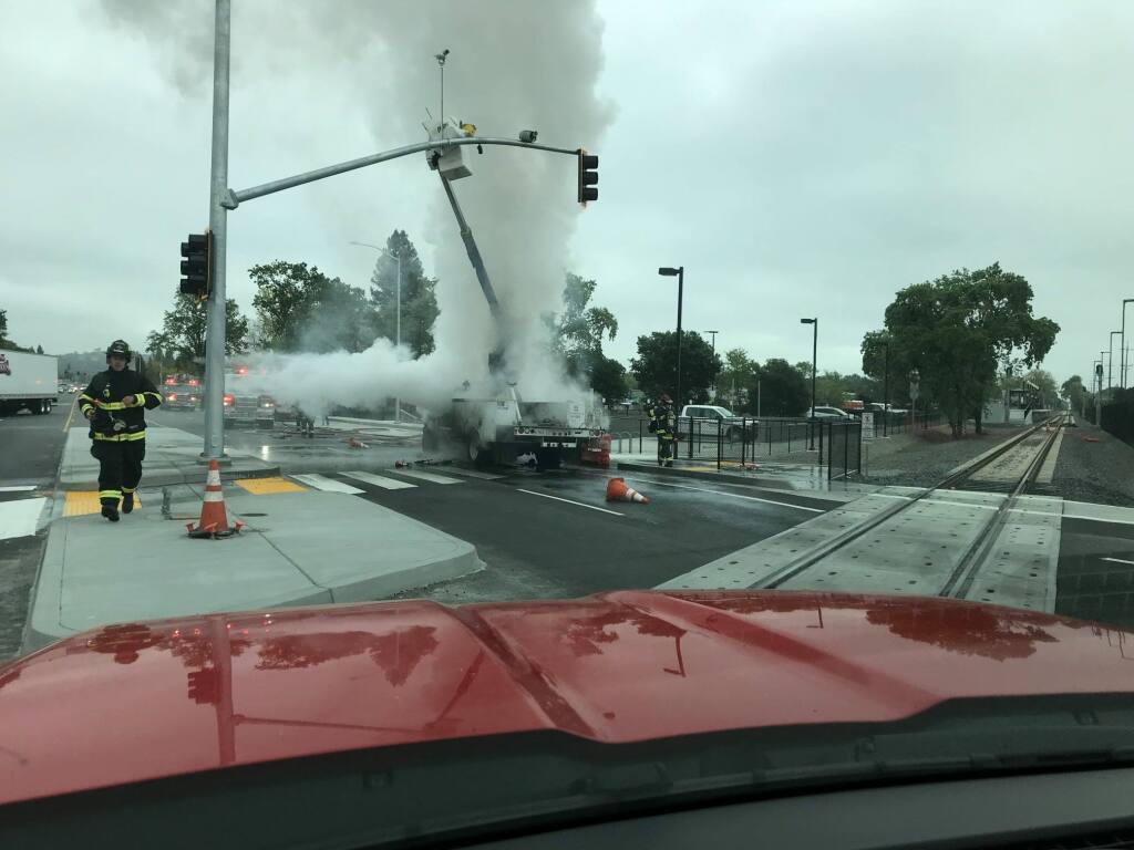 Firefighters tackle a commercial truck fire in which a CHP sergeant directed rescue of the truck driver. He had been hoisted in the boom when the fire broke out. (Sonoma County Fire District/Facebook)