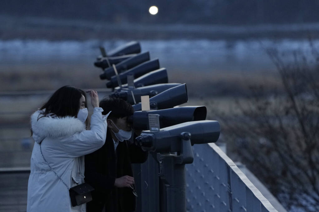 A couple watches the North Korean side at the Imjingak Pavilion in Paju, near the border with North Korea, South Korea, Friday, Jan. 14, 2022. North Korea on Friday fired two short-range ballistic missiles in its third weapons launch this month, officials in South Korea said, in an apparent reprisal for fresh sanctions imposed by the Biden administration for its continuing test launches. (AP Photo/Ahn Young-joon)