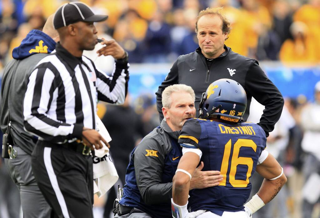 West Virginia coach Dana Holgorsen looks on as cornerback Terrell Chestnut (16) is looked over by the medical staff during the second half of the Mountaineers' game against Baylor in October. Chestnut left the game with a concussion. (Chris Jackson / Chris Jackson)