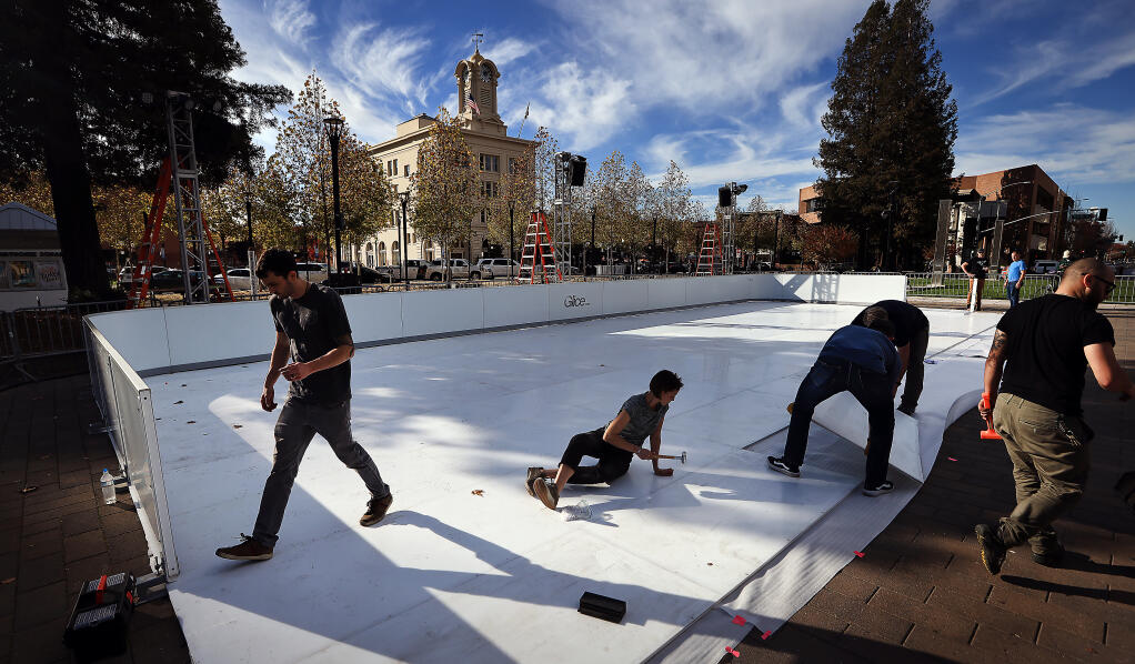 People representing the Santa Rosa Metro Chamber, its affiliate Downtown Santa Rosa, Visit Santa Rosa and downtown business owners put together a portable ice rink from Glice USA, a synthetic surface meant to simulate ice, Wednesday, Nov. 17, 2021 at Old Courthouse Square in Santa Rosa.  (Kent Porter / The Press Democrat) 2021