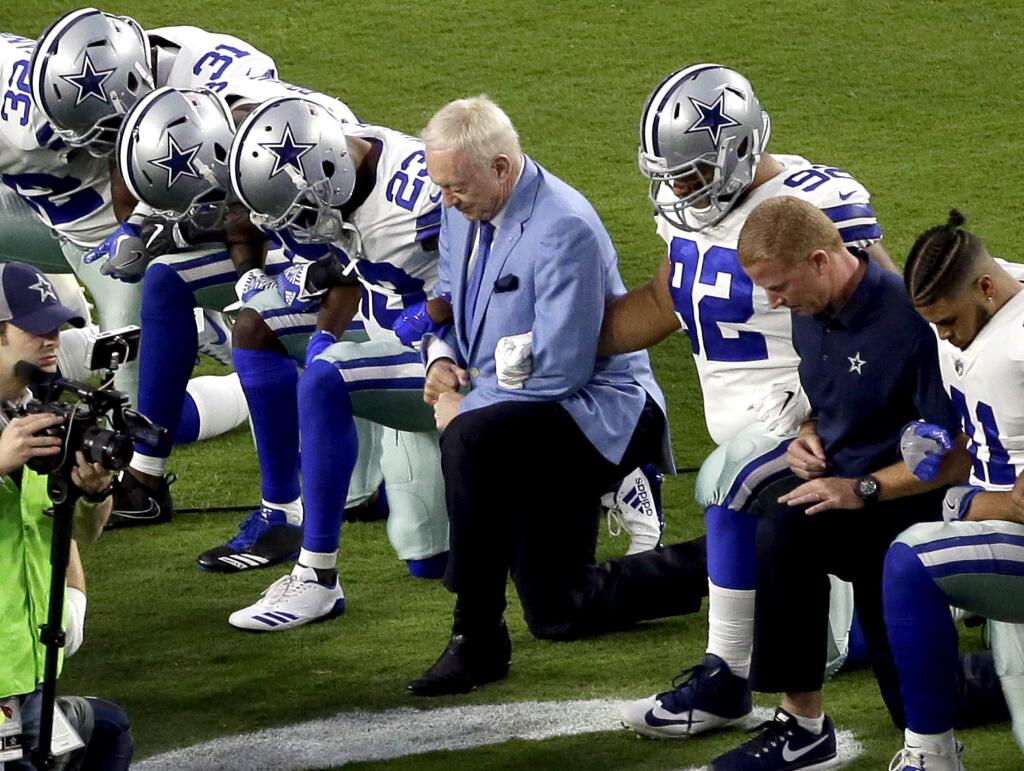 In this Monday, Sept. 25, 2017, file photo, the Dallas Cowboys, led by owner Jerry Jones, center, take a knee prior to the national anthem before a game against the Arizona Cardinals in Glendale, Ariz. (AP Photo/Matt York, File)