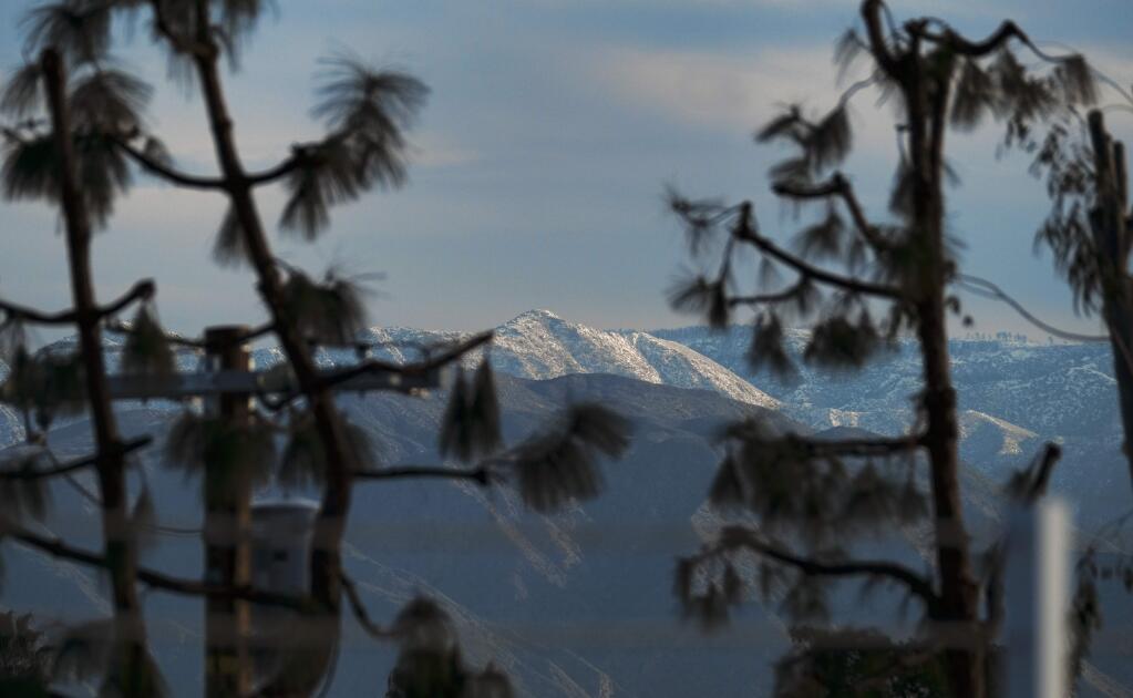 Mountain tops East of Los Angeles are covered with snow seen from Los Angeles, Tuesday, Jan. 24, 2017. After years of drought and barren slopes, skiers and boarders have a bonanza of snow at resorts from the Sierra Nevada to the mountain ranges of Southern California following a barrage of storms. East of Los Angeles, the Bear Mountain-Snow Summit resorts report their largest January total, 70 inches, while Mountain High says the latest storm dropped the most snow in five years. (AP Photo/Richard Vogel)