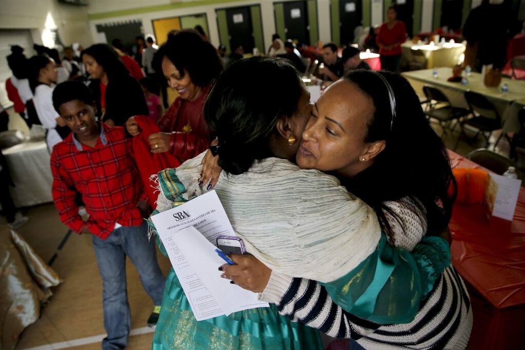 Tsehainesh Abraham, right, hugs Hiwot Kiflay during a luncheon at Roseland Elementary School honoring 10 Eritrean families who lost their homes during the October wildfires. Photo in Santa Rosa, on Sunday, November 19, 2017. (BETH SCHLANKER/ The Press Democrat)