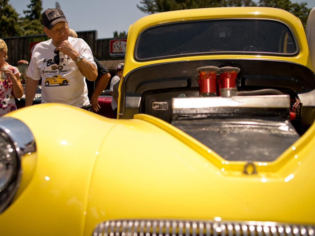 Ed 'Bing' Binggeli looks over the 1941 Ford Flathead engine of his 1941 Willys coupe after unveiling the car during his 90th birthday party at Stoke Ranch in Santa Rosa, Calif., on July 20, 2013. (Alvin Jornada / For The Press Democrat)