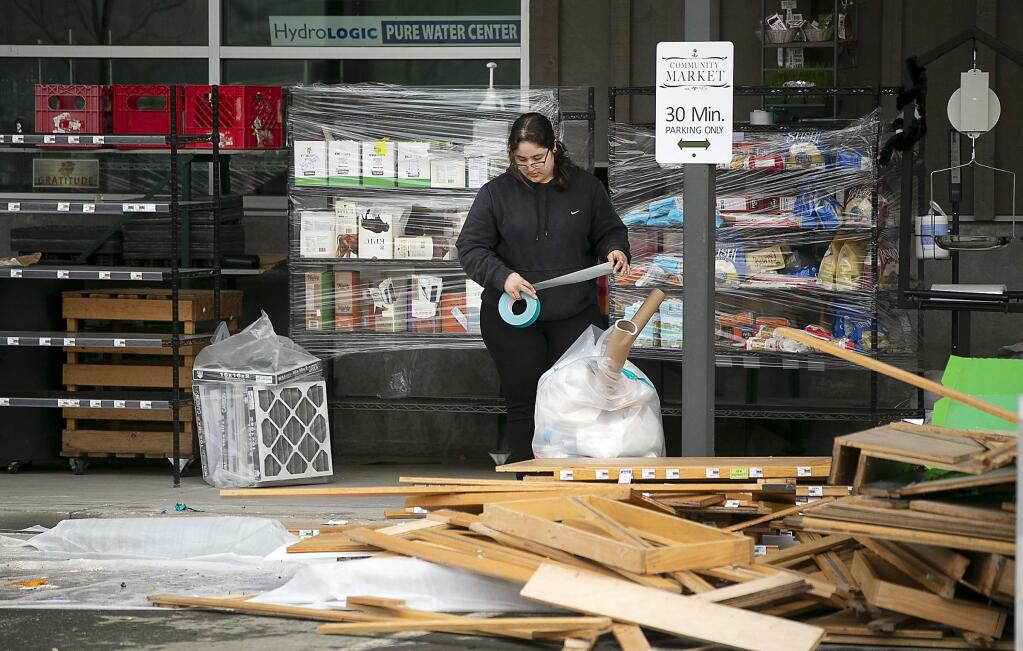 Workers clean up outside of the Community Market in The Barlow business district in Sebastopol on Monday, March 4, 2019. (JOHN BURGESS/ PD)