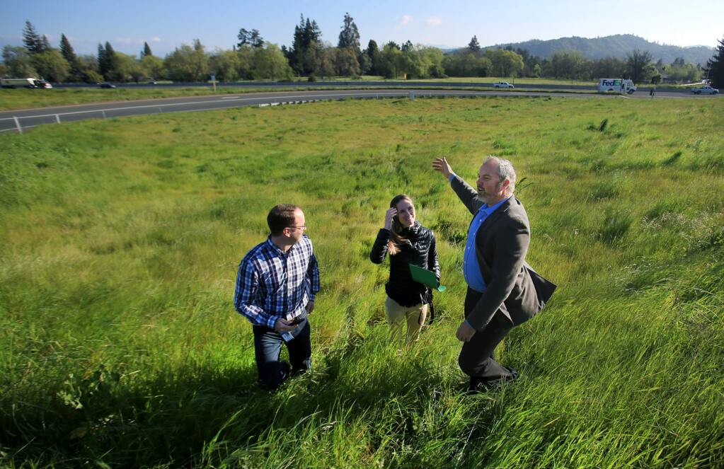 Sonoma County Supervisor James Gore talks with county officials Brad Sherwood and Jennifer Larocque, Thursday March 30, 2017 in Santa Rosa, after Gore did a Facebook live video about the county undertaking a project to replant trees in areas, such as the Airport Boulevard interchange, background, that were removed due to the Highway 101 widening project. (Kent Porter / The Press Democrat) 2017