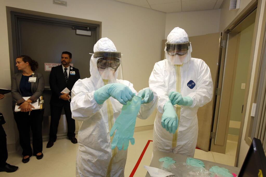 In this photo provided by the UCLA Health System, doctors and staff participate in a preparadness exercise on diagnosing and treating patients with Ebola virus symptoms, at the Ronald Reagan UCLA Medical Center in Los Angeles. (AP Photo/UCLA Health System, Reed Hutchinson)