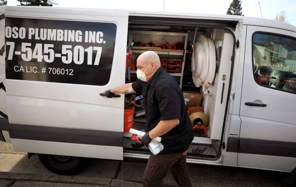 Jim Curoso of Curoso Plumbing Inc., masks and gloves up on a job in Cotati, Wednesday, March 25, 2020. During the shelter in place order, Curoso's business is considered essential. (Kent Porter / The Press Democrat) 2020